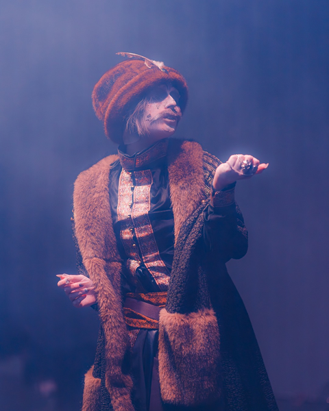 Cosplayer performing in a brown coat