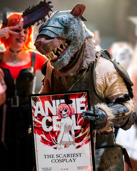 Creature cosplayer holding a Scariest Cosplay award