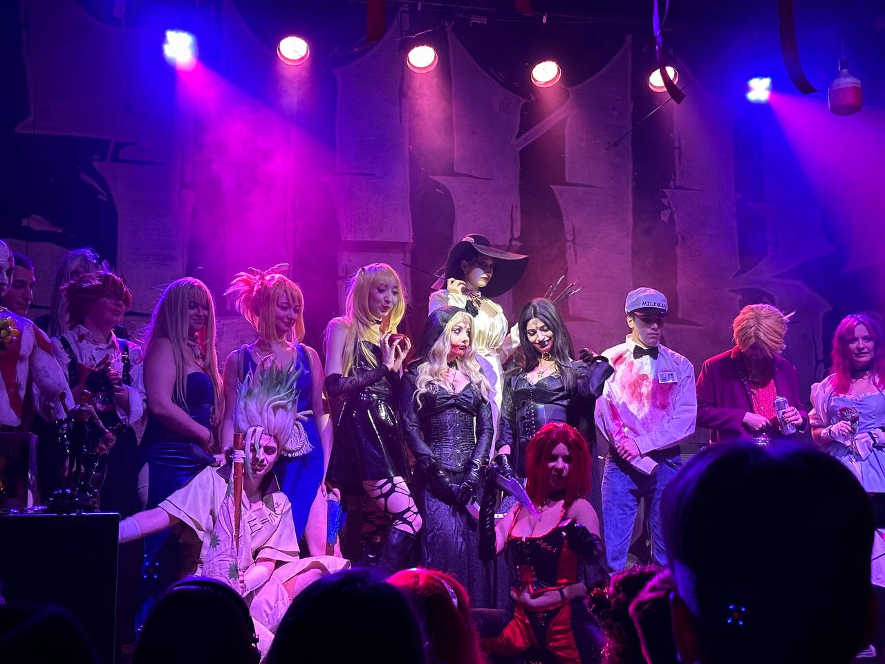 Cosplay participants together on the purple-lit stage